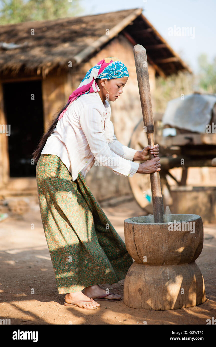 Girl grinding rice Stock Photo