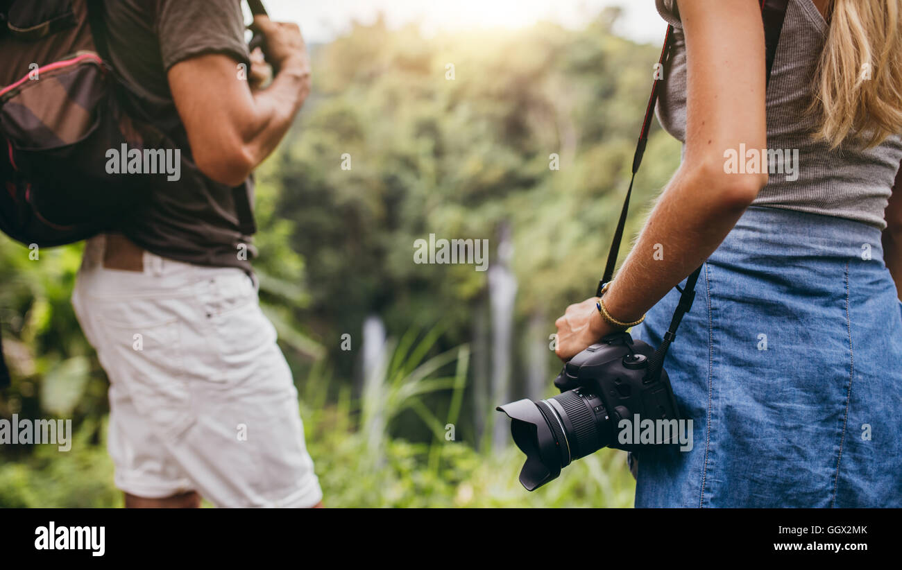 Close up shot of hiker couple standing in nature. Woman with DSLR camera and man with backpack. Stock Photo