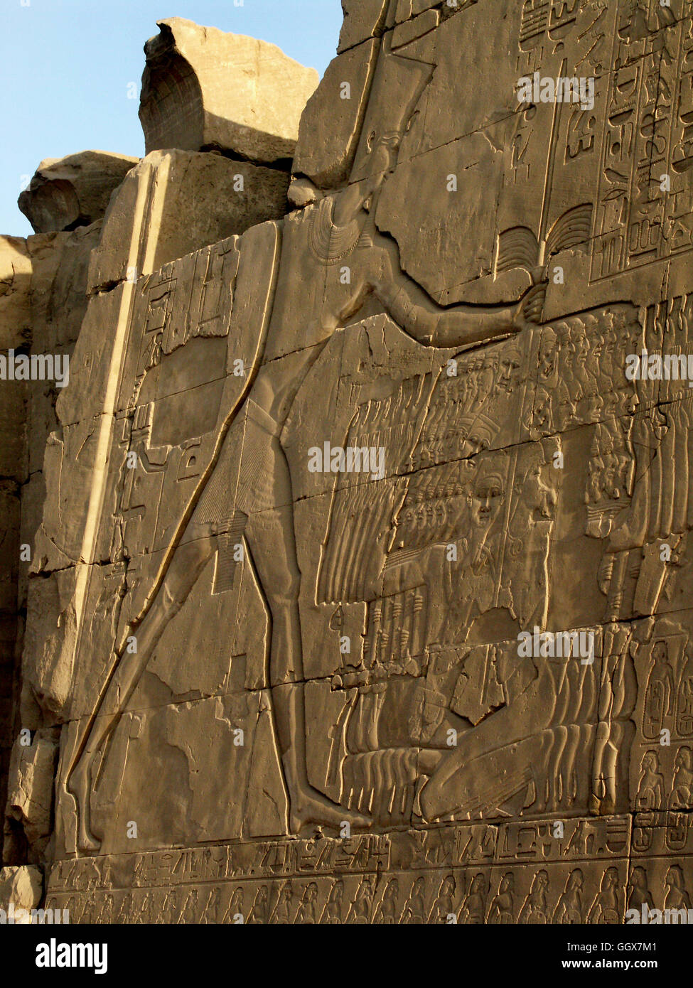 Wall relief of pharaoh Ramesis IV smiting enemies in the courtyard of the Temple of Karnak at Luxor – Egypt. Stock Photo