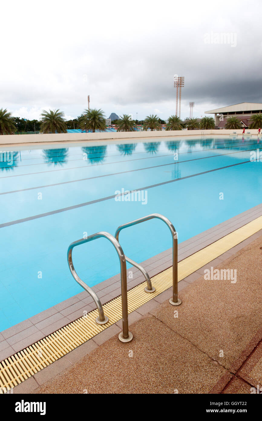 blue water wave in swimming pool reflects with sunlight , blue tile