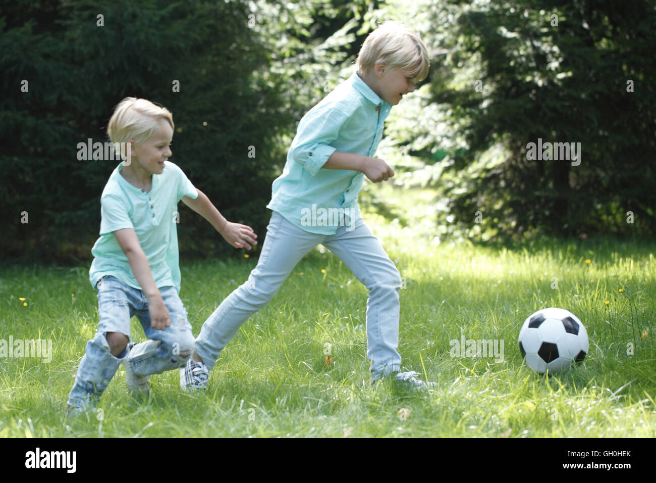 Happy children playing football in summer park Stock Photo - Alamy
