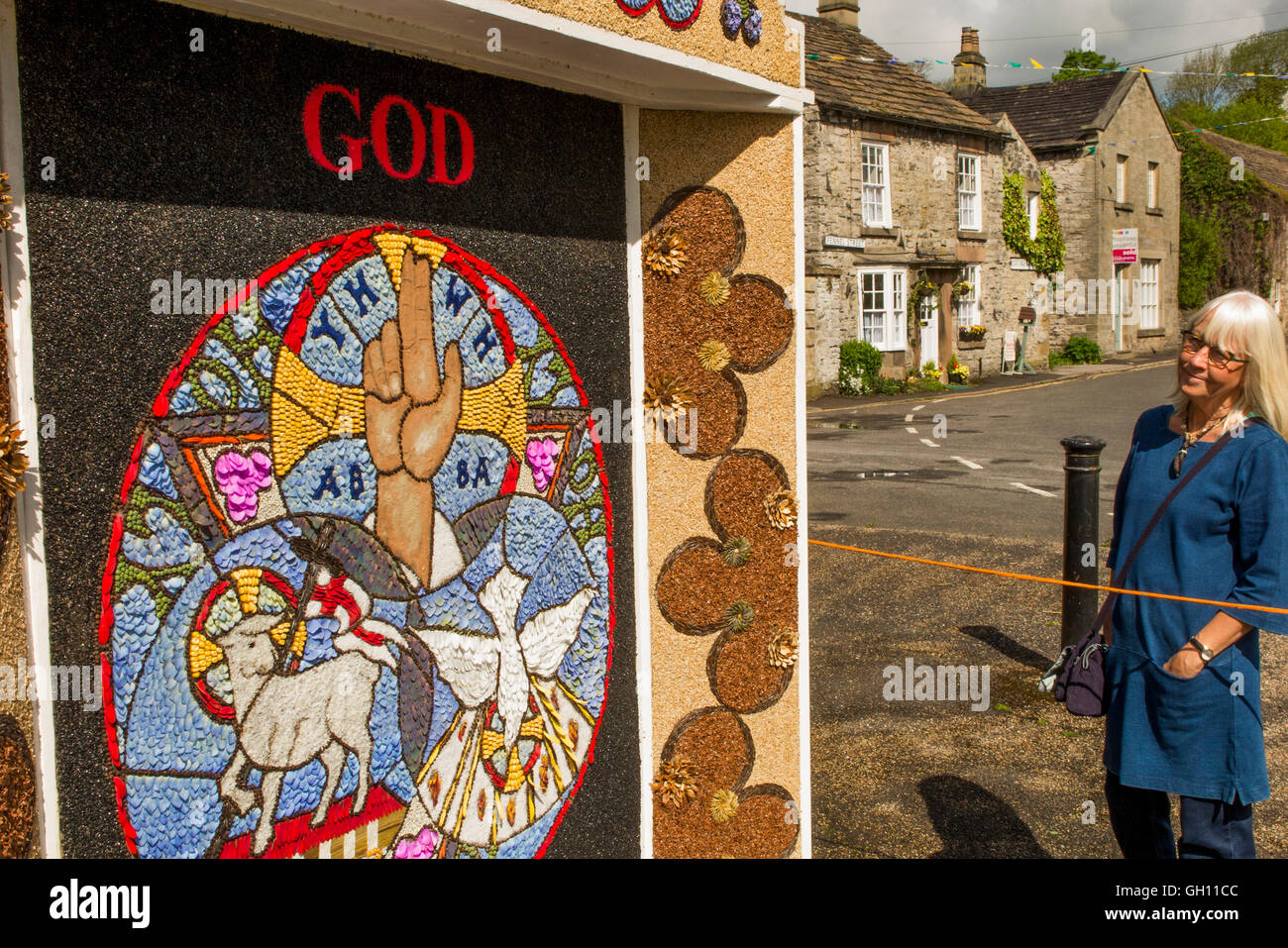 UK, England, Derbyshire, Ashford in the Water, Fennel St, vistor looking at well dressing picture made of petals Stock Photo