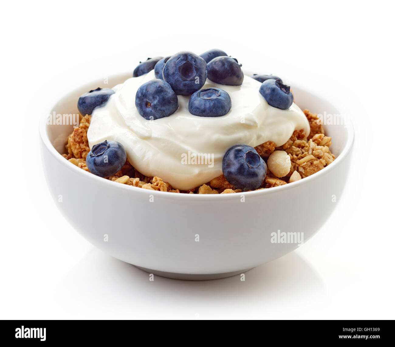 Bowl of whole grain muesli with blueberries and yogurt isolated on white background Stock Photo