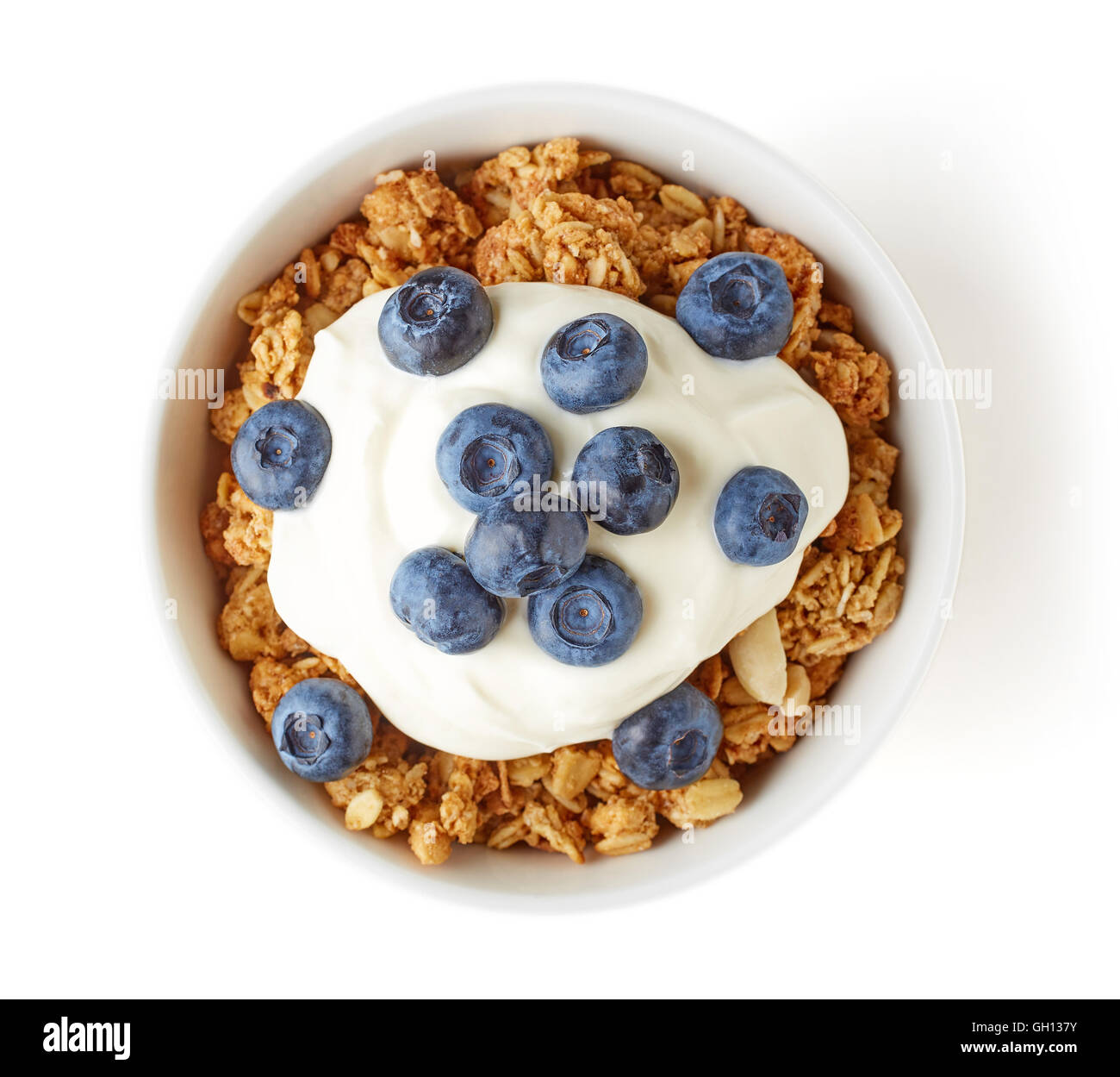 Bowl of whole grain muesli with blueberries and yogurt isolated on white background, top view Stock Photo