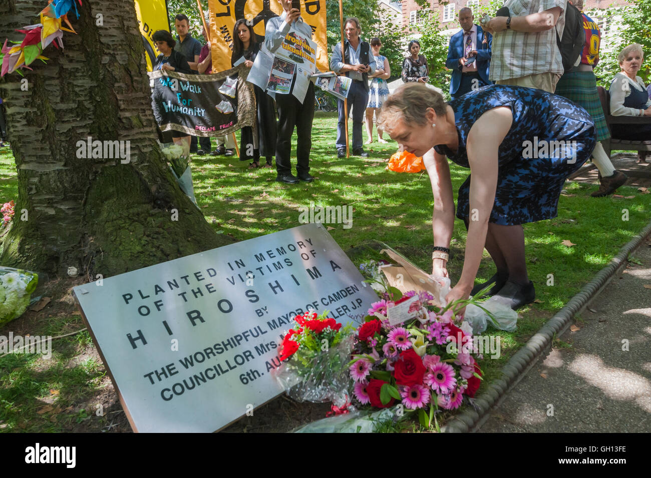 London, UK. 6th August 2016. Kate Hudson of CND lays flowers at  the commemorative cherry tree at the CND ceremony in memory of the victims, past and present on the 71st anniversary of the dropping of the atomic bomb on Hiroshima and the second atomic bomb dropped on Nagasaki three days later. Peter Marshall/Alamy Live News Stock Photo