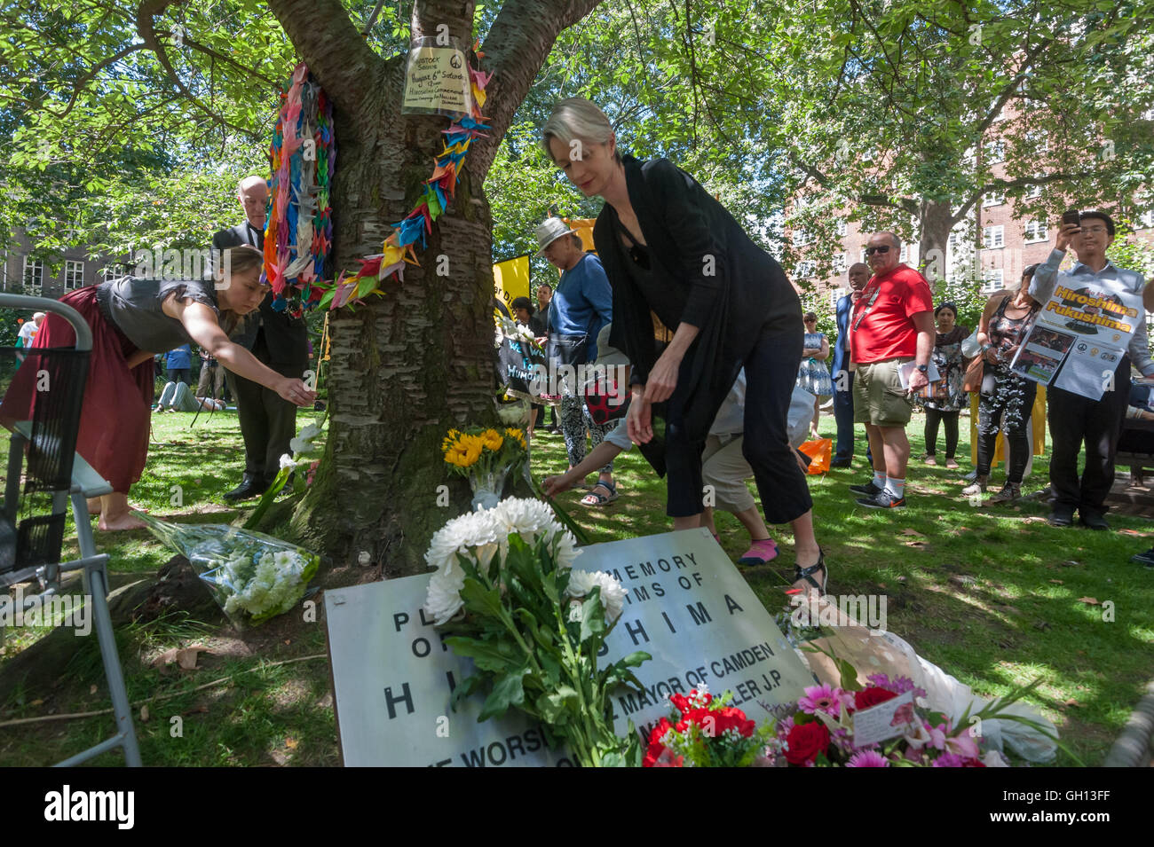 London, UK. 6th August 2016. People lay flowers at  the commemorative cherry tree at the CND ceremony in memory of the victims, past and present on the 71st anniversary of the dropping of the atomic bomb on Hiroshima and the second atomic bomb dropped on Nagasaki three days later. Peter Marshall/Alamy Live News Stock Photo