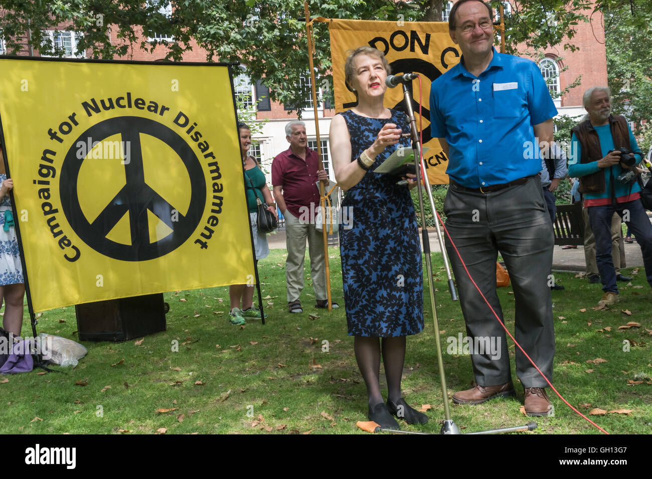 London, UK. 6th August 2016. Kate Hudson of CND and Tim Wallis of Quaker, Peace & Social Witness chair the London CND  ceremony in memory of the victims, past and present on the 71st anniversary of the dropping of the atomic bomb on Hiroshima and the second atomic bomb dropped on Nagasaki three days later. After a number of speeches and performances there was a two minute's silence during which the Mayor of Camden and others laid flowers around the commemorative cherry tree. Peter Marshall/Alamy Live News Stock Photo