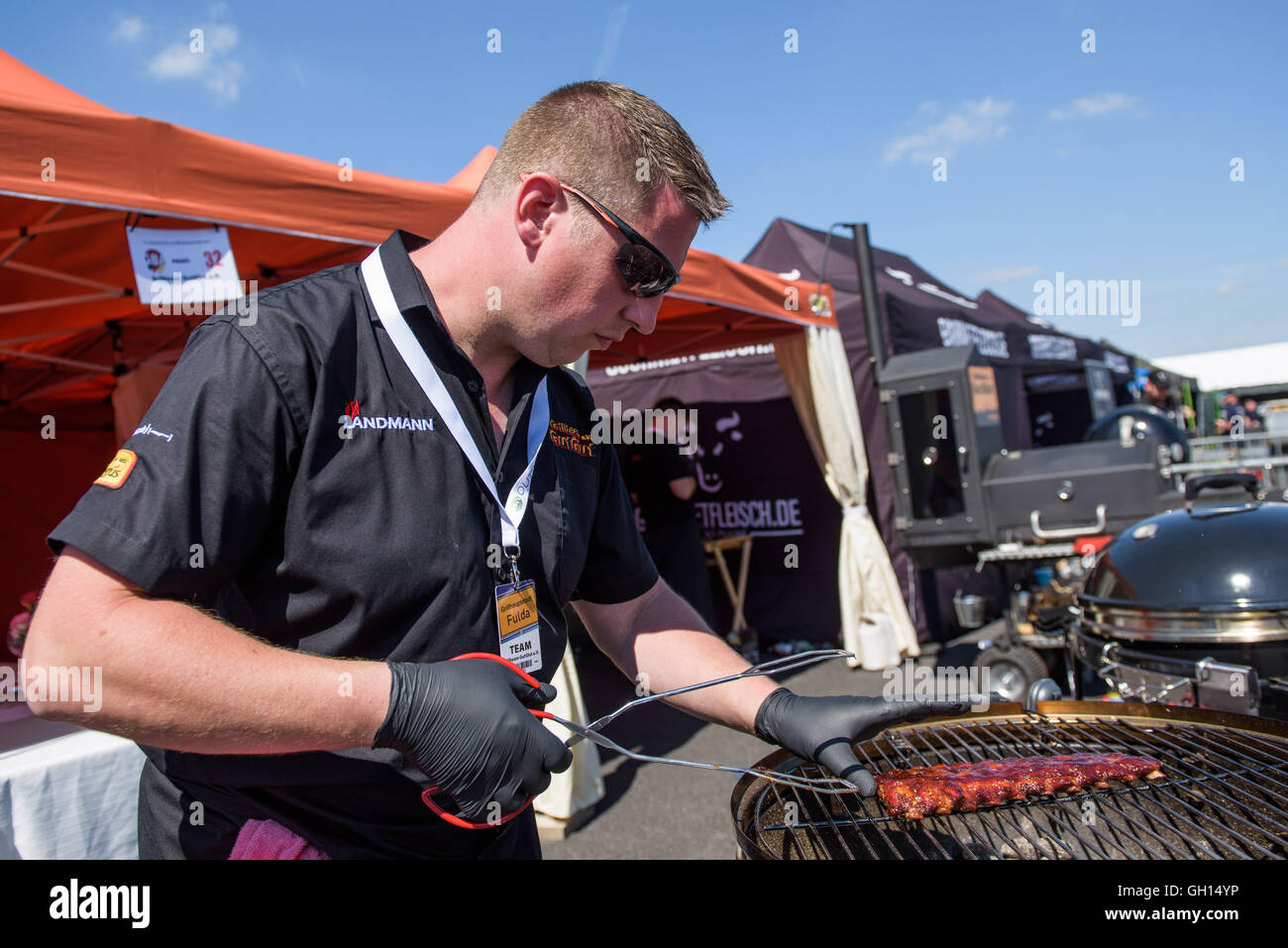 Fulda, Germany. 07th Aug, 2016. Patrick Damsma from Grill-team 'GutGlut'  cooks spare ribs during the 21st German BBQ Championships in Fulda,  Germany, 07 August 2016. Around 40 teams will be grilling in