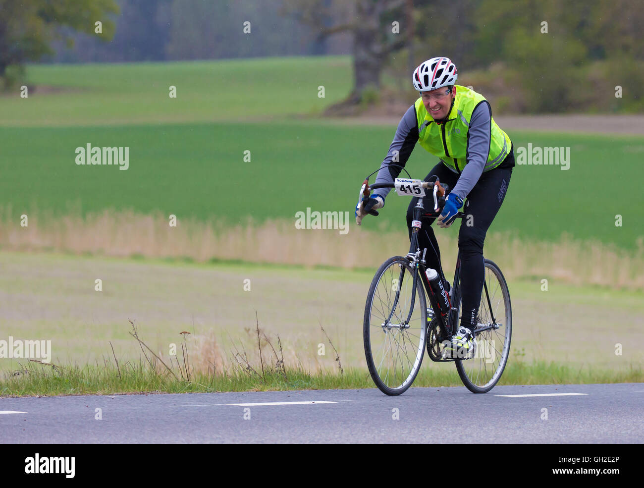 Participant in a smaller bike race, (90 km rural road) for both professionals and amateurs. A rainy Stock Photo