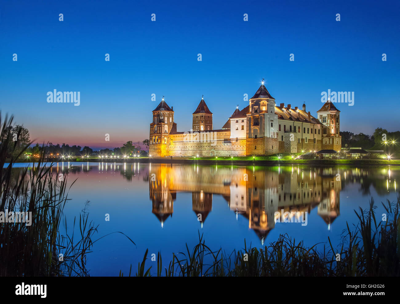 Mir Castle reflecting in water in the evening, Belarus Stock Photo