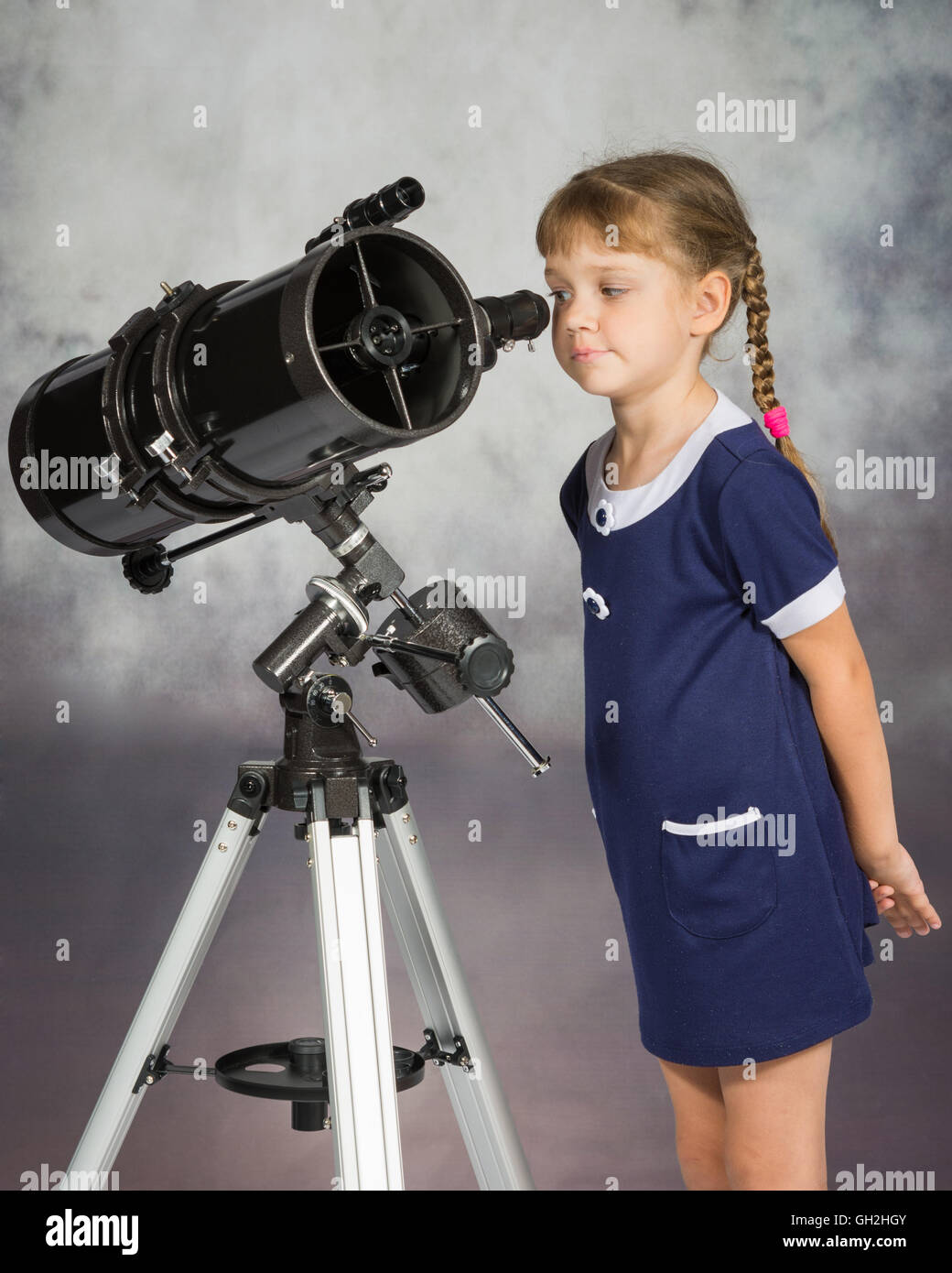 Girl lover of astronomy with interest looks in the eyepiece of the telescope Stock Photo