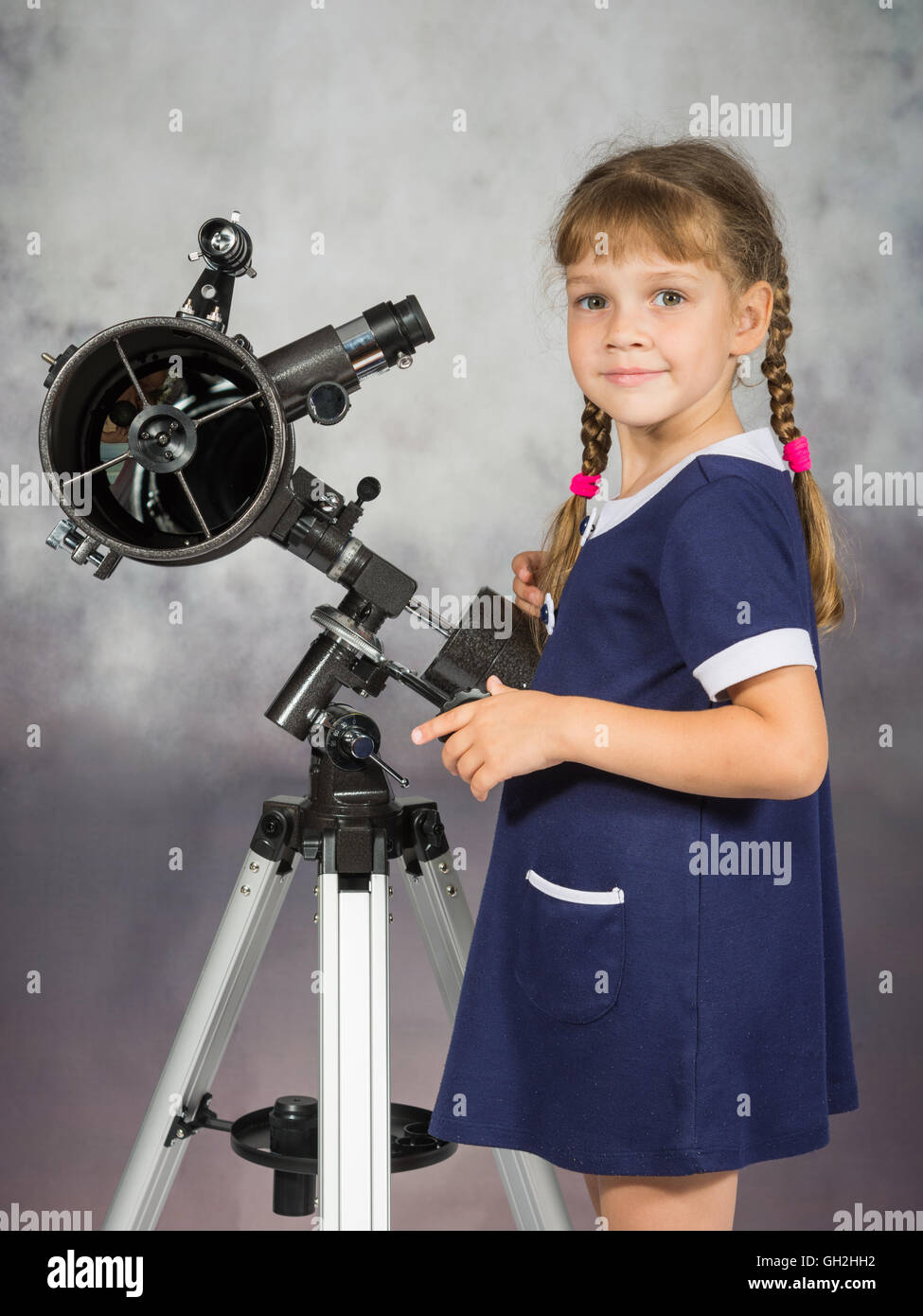 Girl lover of astronomy stands next to the telescope and looked into the frame Stock Photo