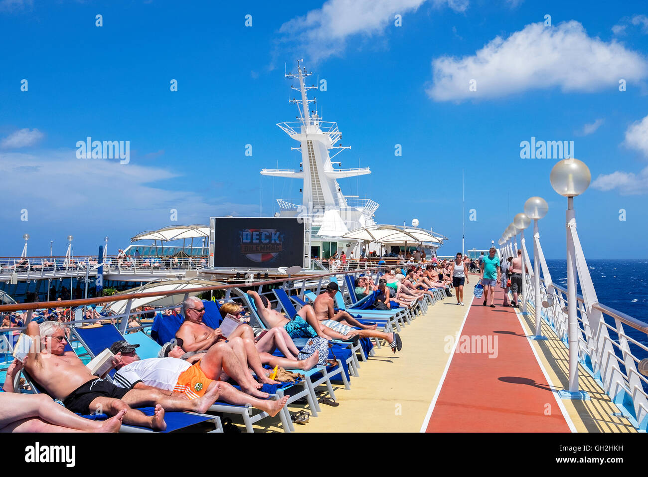 Passengers enjoying the sun on the outer deck of a Thomsons cruise ship Stock Photo