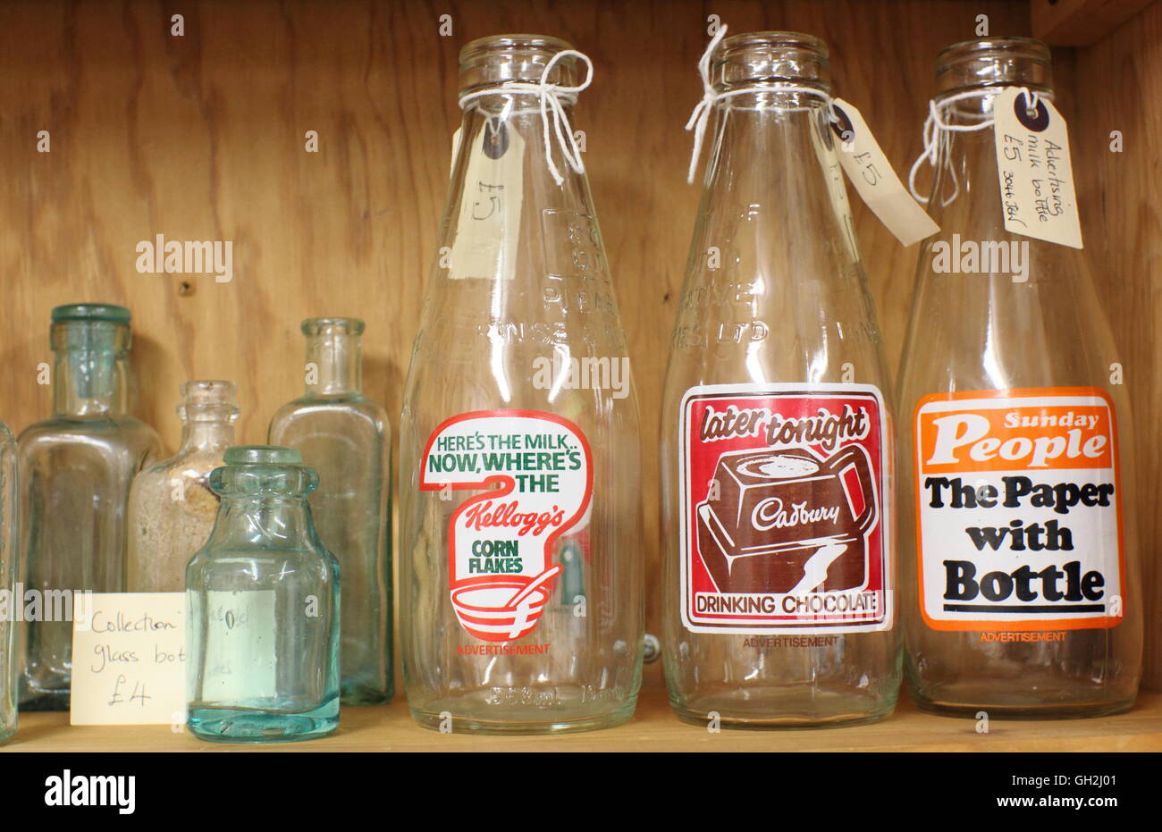 Vintage bottles on sale display featuring advertisements for Kellogs, Cadbury and the Sunday People newspaper Stock Photo