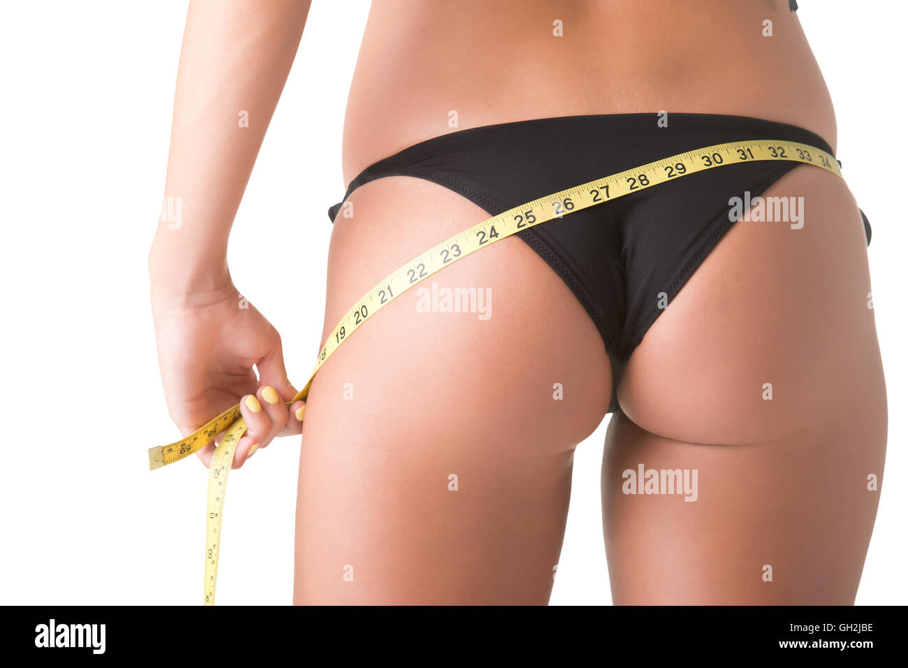 Woman in a bikini measuring her waist, isolated in white Stock Photo