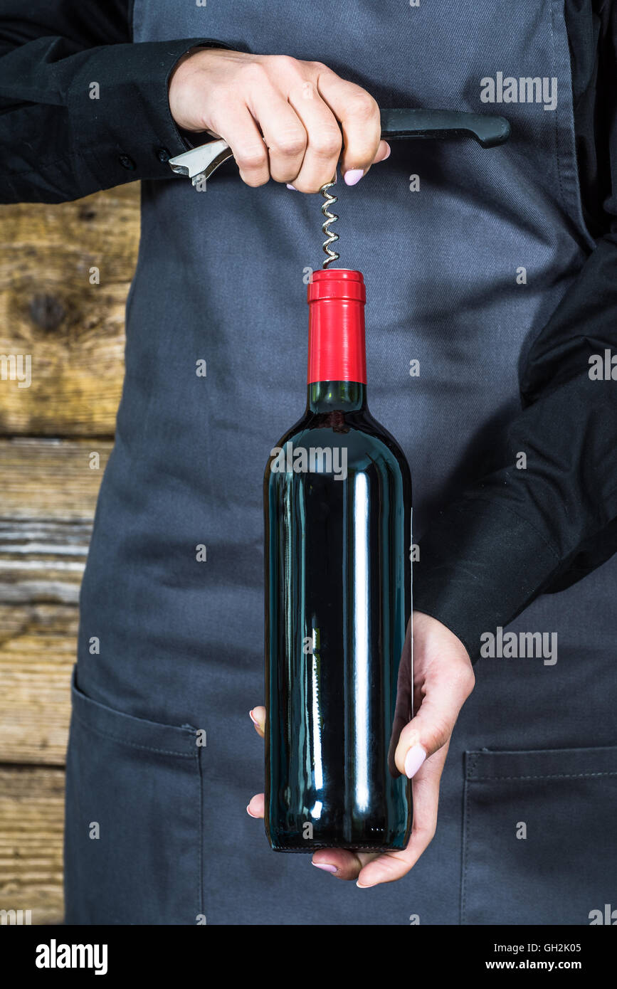 waitress in apron with corkscrew and red wine bottle Stock Photo Alamy