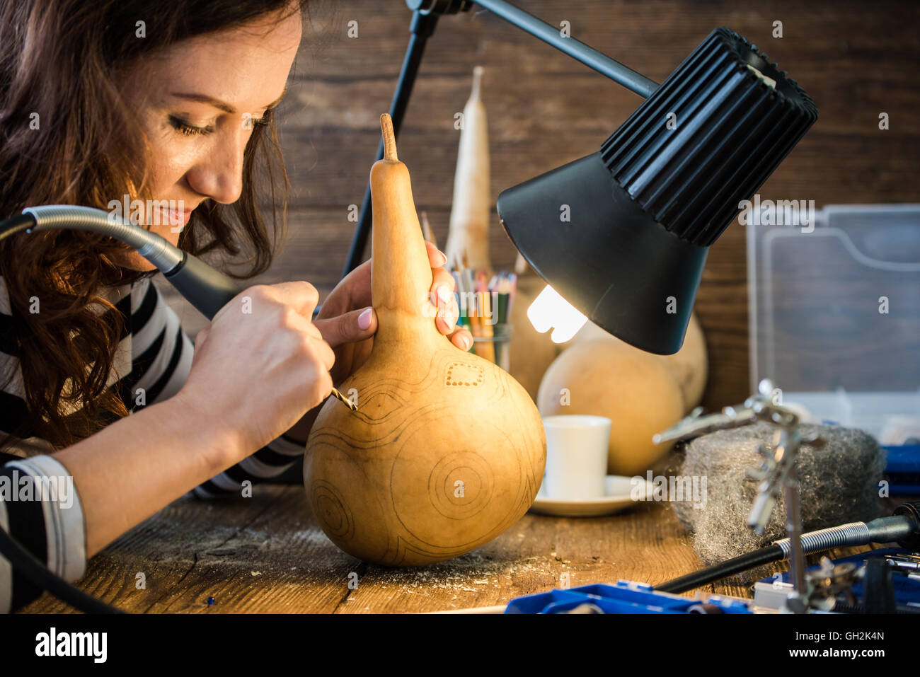 young woman skilled artisan in workshop working with hand tools Stock Photo
