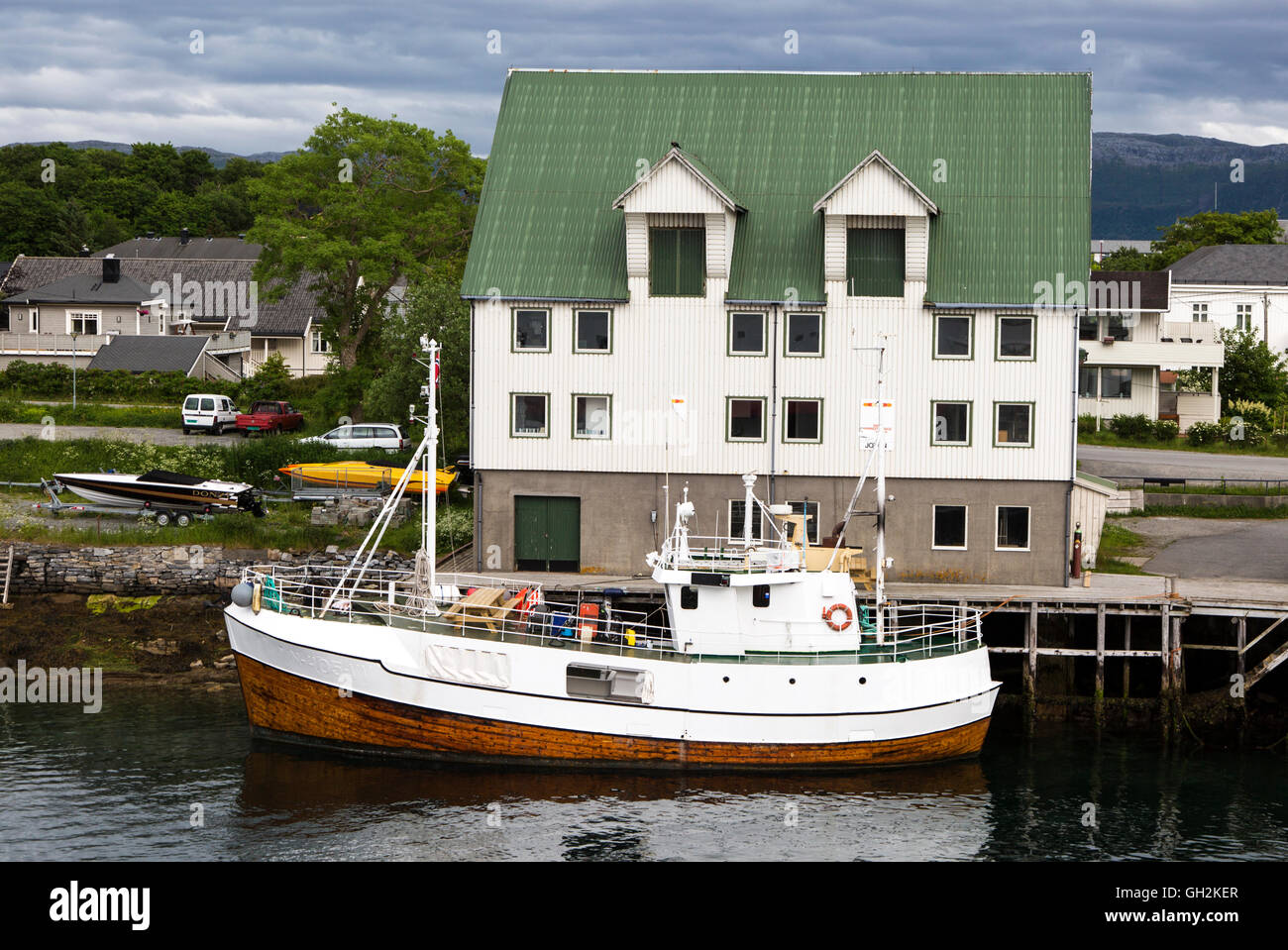 Boat outside waterside building, Bronnoy,  Bronnoysund, Nordland, Norway Stock Photo