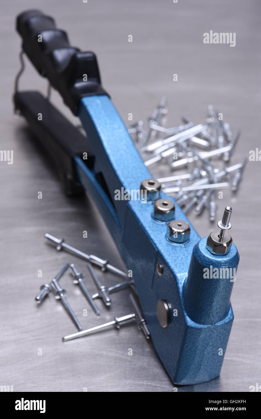 Hand rivet tool on metal surface Stock Photo