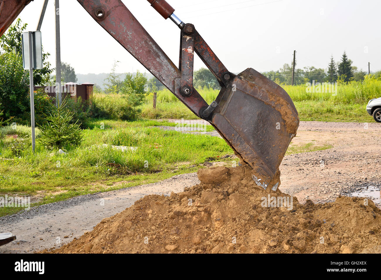 Excavator bucket digging a trench in the dirt ground Stock Photo Alamy