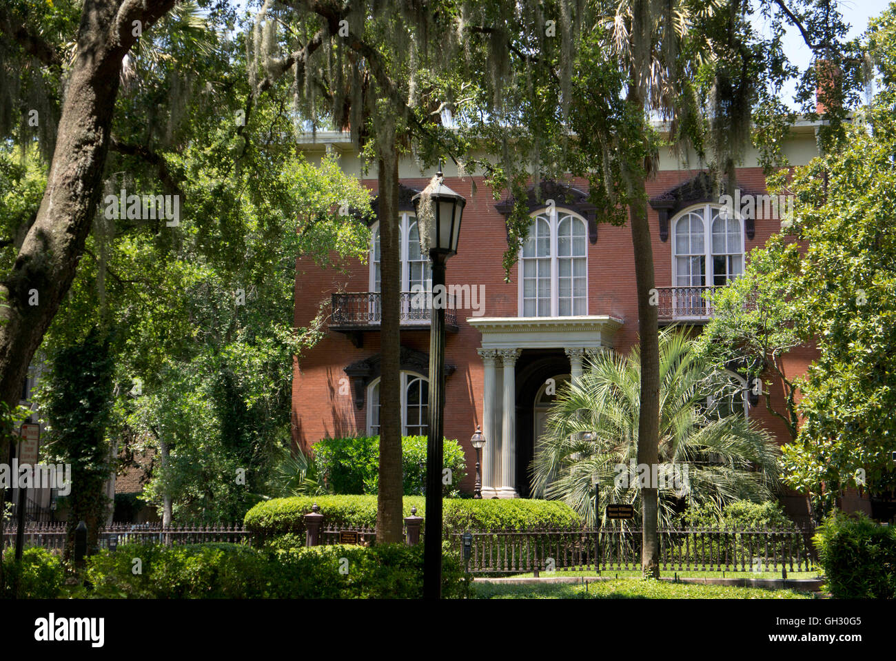 Mercer Williams House/ Museum, framed by Live Oaks on Pulaski Square.  Savannah, Georgia. Stock Photo