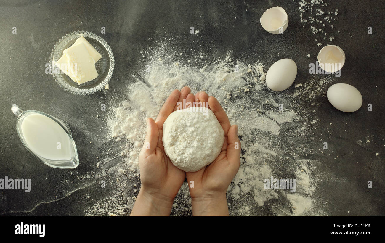 Woman's hands knead dough on table with flour Stock Photo - Alamy
