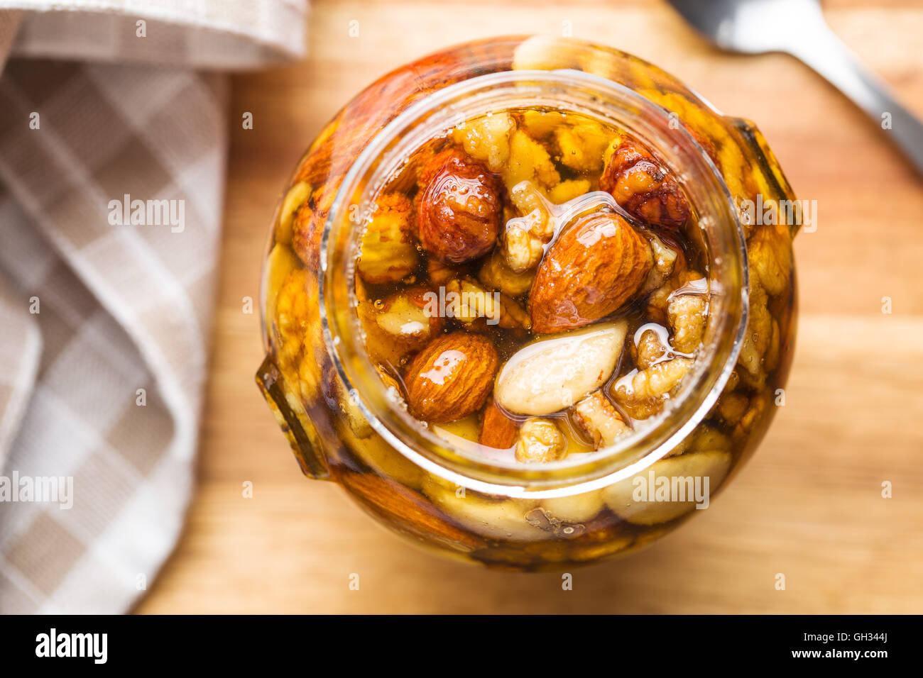 Honey and nuts in jar on wooden table Stock Photo Alamy