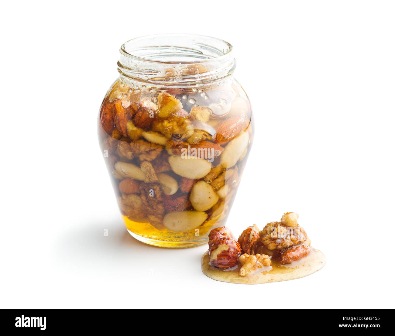 Healthy mix of natural honey with different nuts in a jar on white