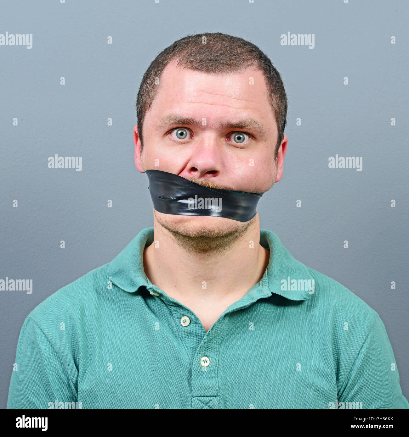 Kidnapped man with tape over his mouth Stock Photo