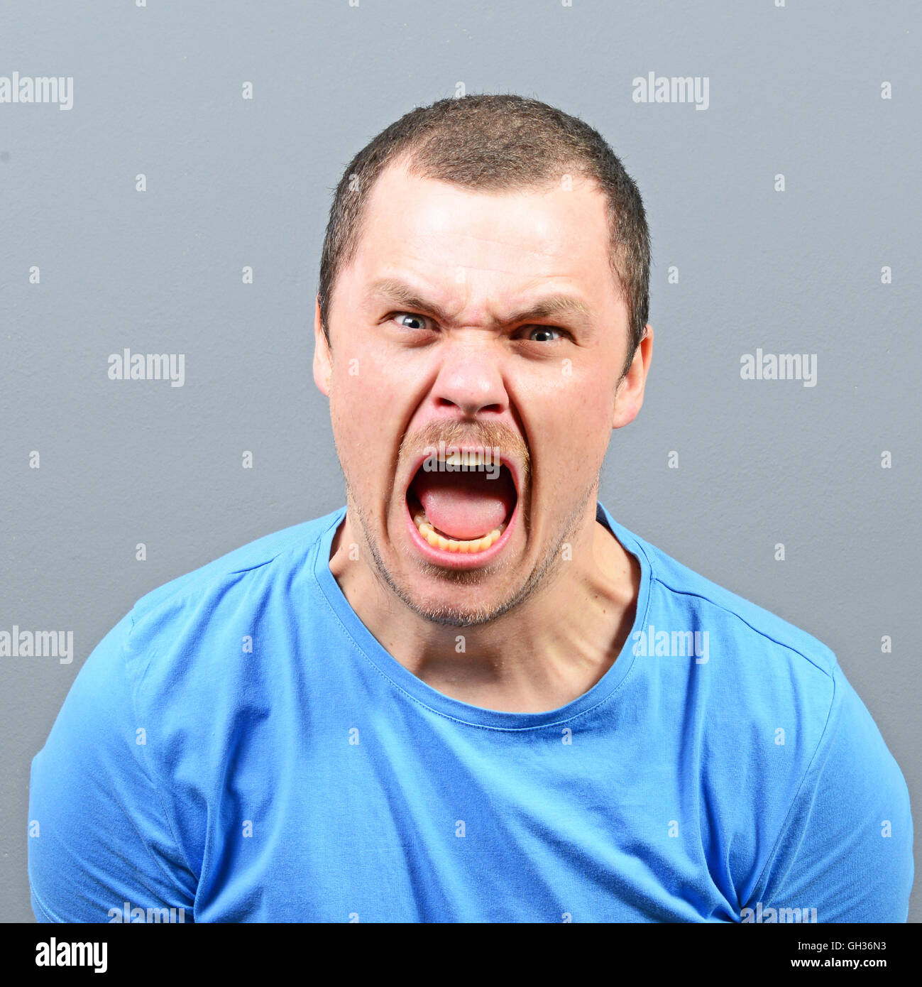 Portrait of a angry man screaming against gray background Stock Photo