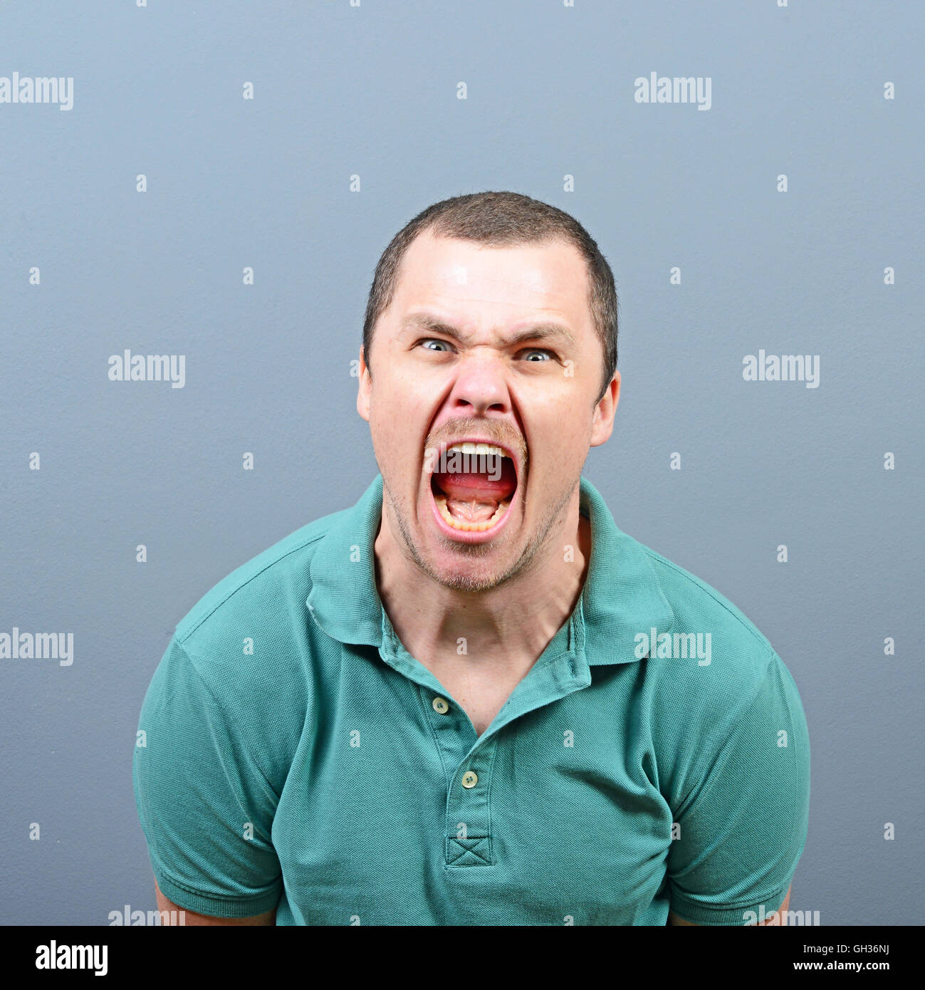 Portrait of a angry man screaming against gray background Stock Photo ...