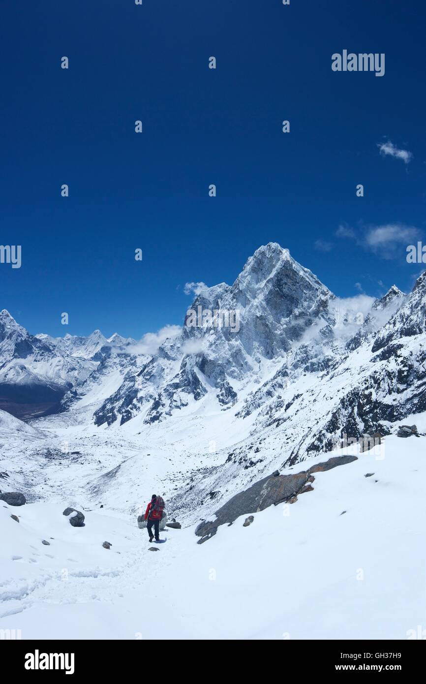 Sherpa guide walking over Cho La Pass with Arakam Tse on right side, Solukhumbu District, Nepal, Asia Stock Photo