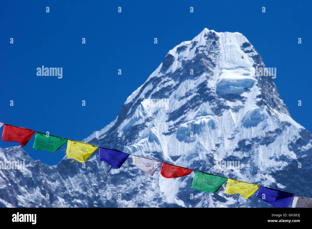 Buddhist prayer flags against Ama Dablam and blue sky, Nepal, Asia Stock Photo