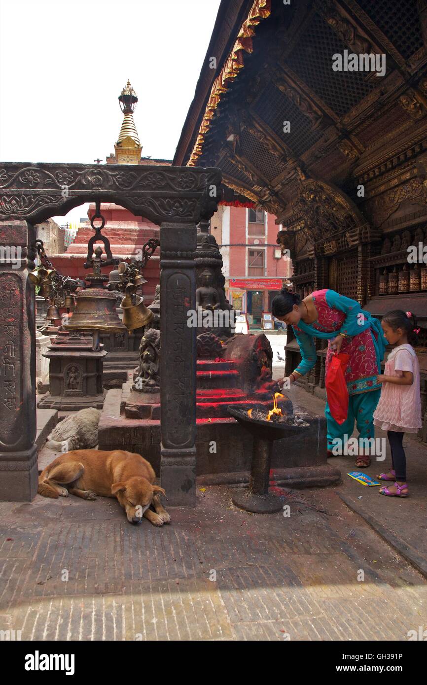 Mother and daughter at Hindu shrine with sleeping dog at Swayambhunath Stupa or Monkey Temple, Kathmandu, Nepal, Asia Stock Photo