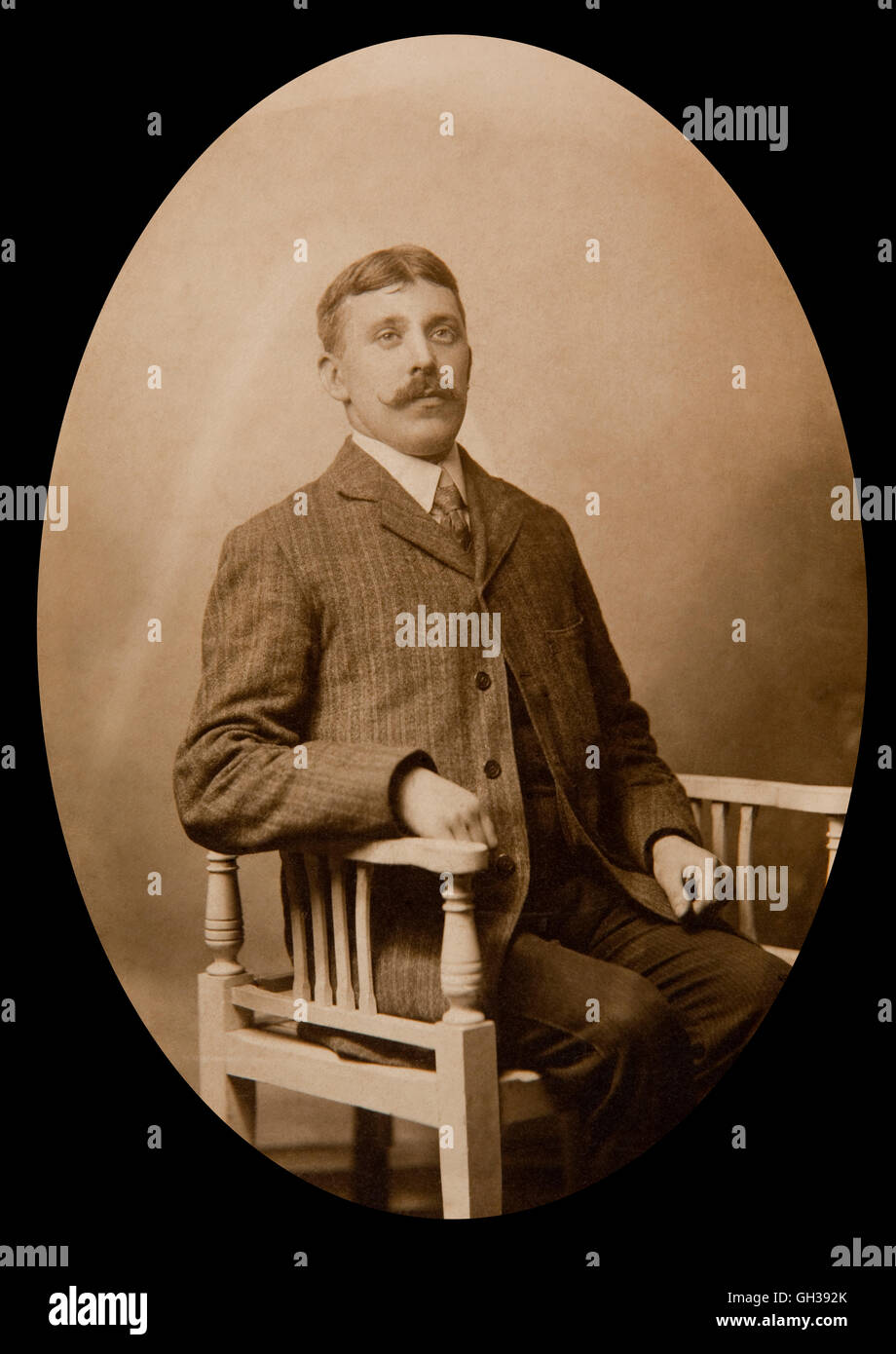 Edwardian studio portrait of man sat in chair Stock Photo