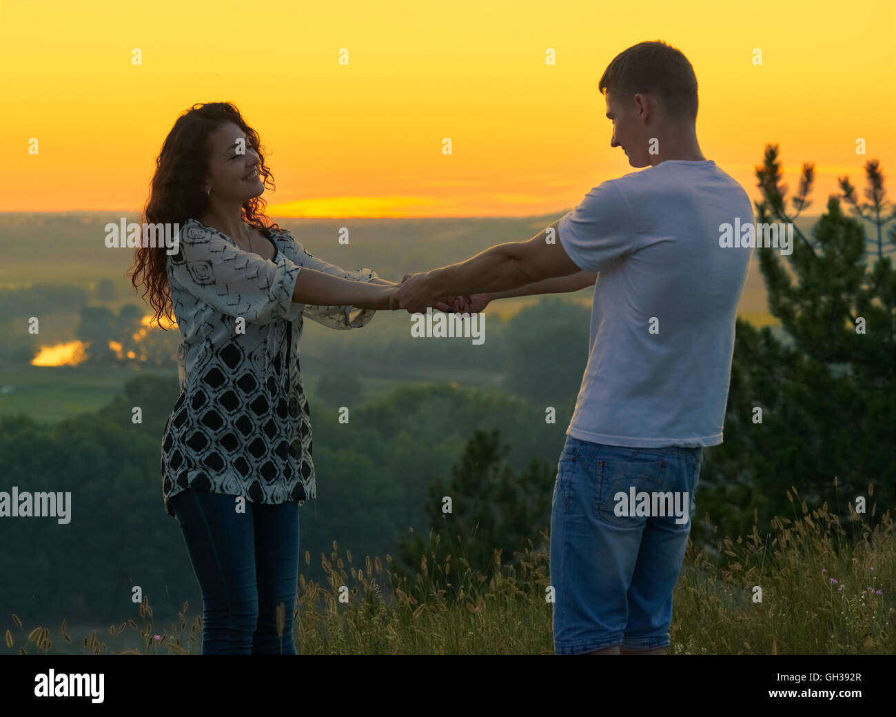 Couple holding hands at sunset hi-res stock photography and images - Alamy