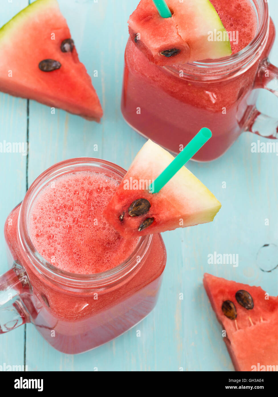 Watermelon smothie and slices on blue background Stock Photo - Alamy