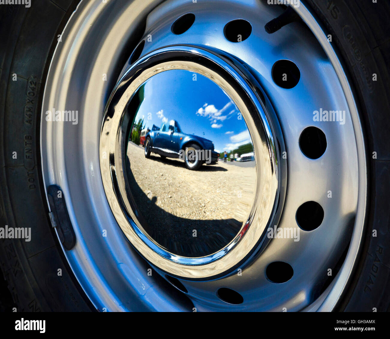 Reflection of a vintage car in the wheel cover of another vintage vehicle Stock Photo