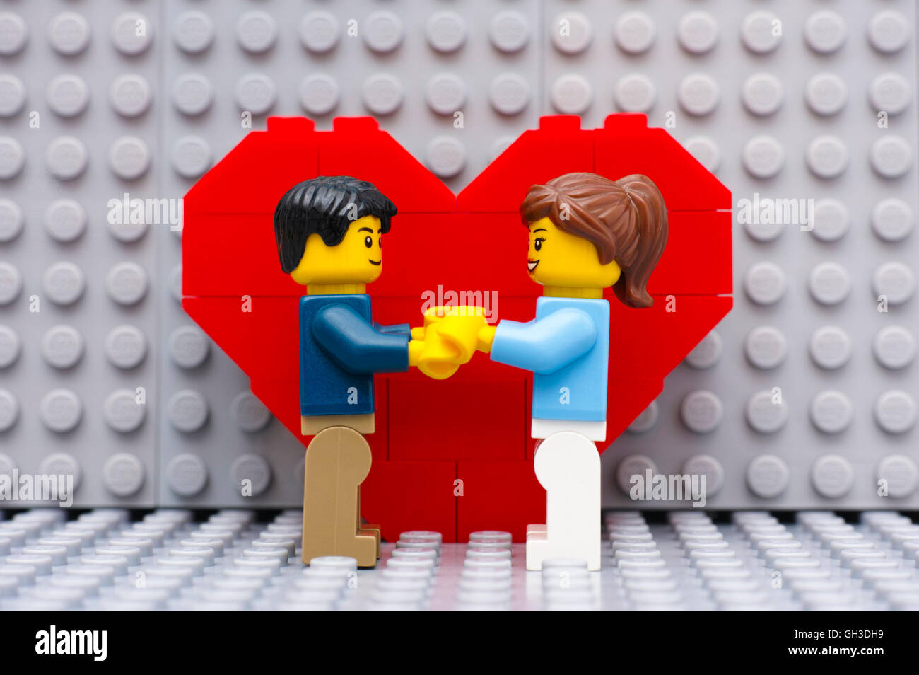 Tambov, Russian Federation - September 03, 2015 Lego couple standing in front of heart on Lego gray baseplate. Studio shot. Stock Photo
