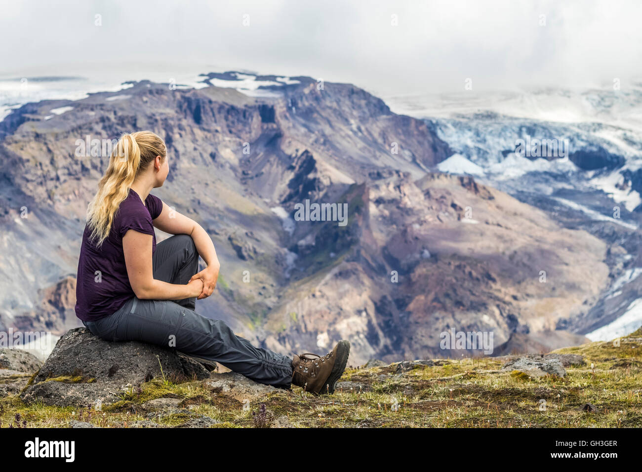 Young woman overlooking the mountains in Iceland. Stock Photo