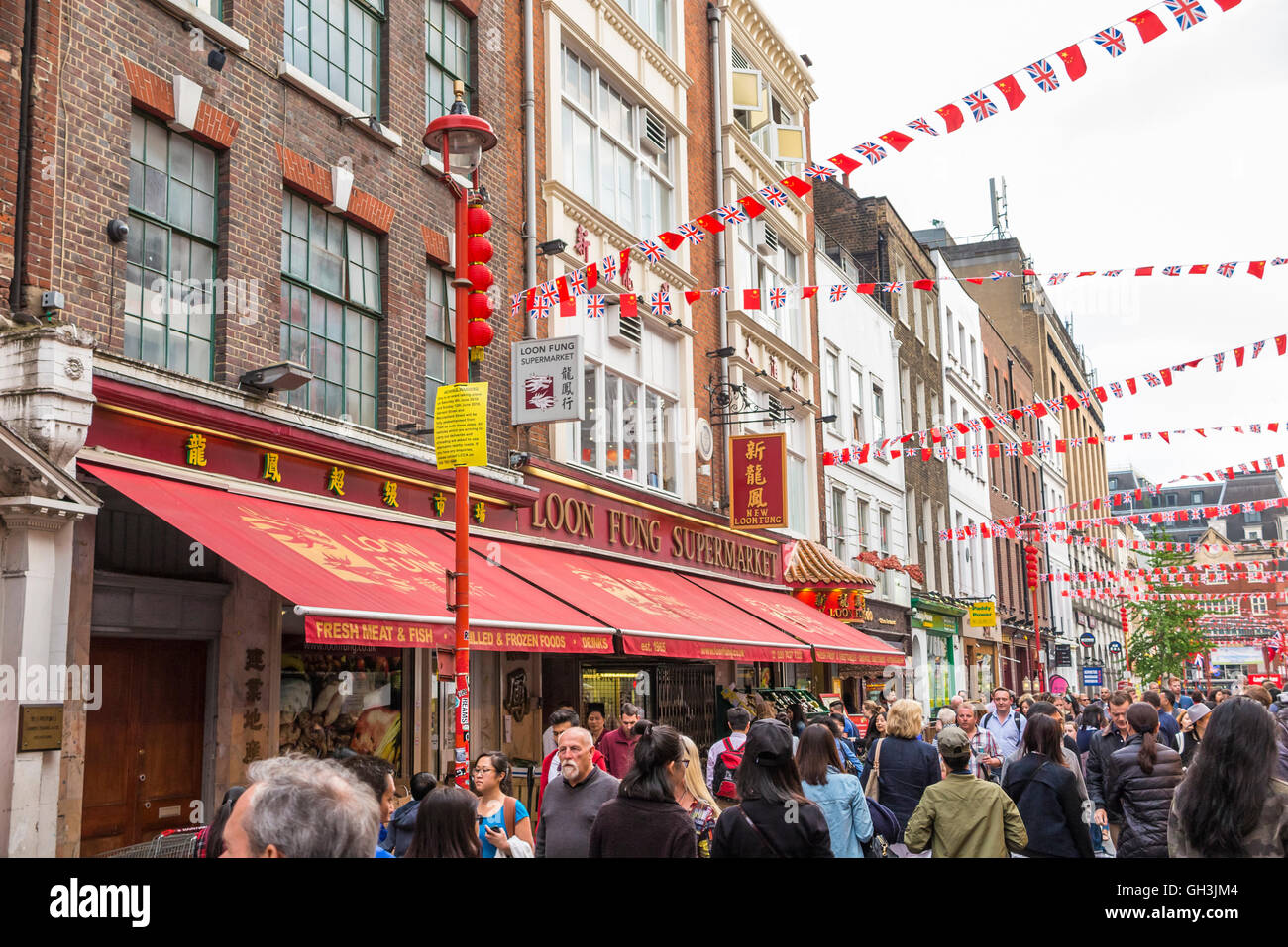 Bustling street scene by Chinese restaurants in Chinatown, West End