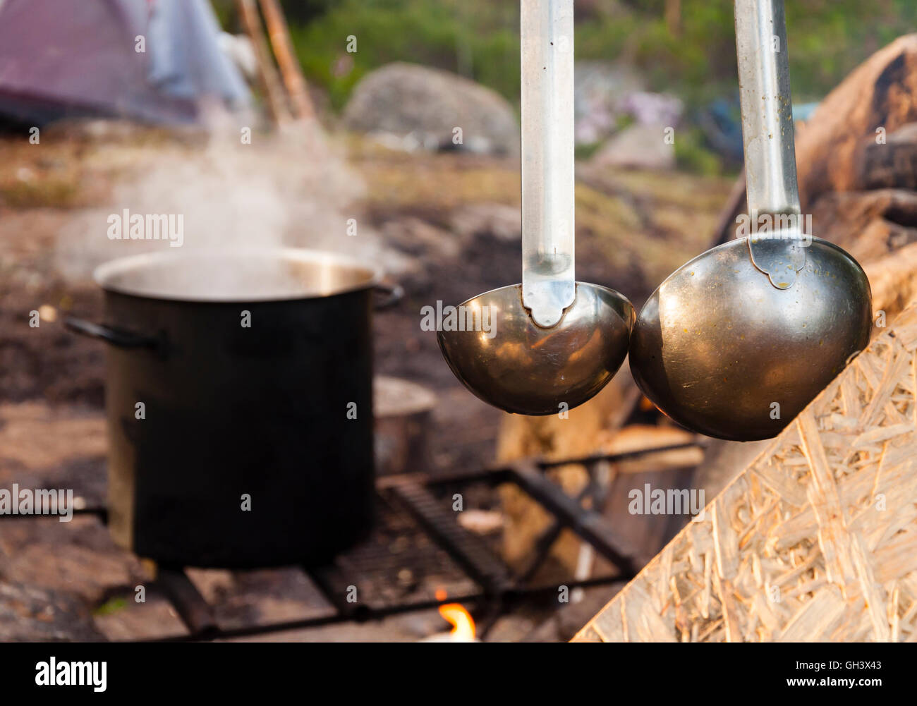 https://c8.alamy.com/comp/GH3X43/cooking-food-in-the-nature-big-pot-on-fire-and-ladle-in-forest-GH3X43.jpg