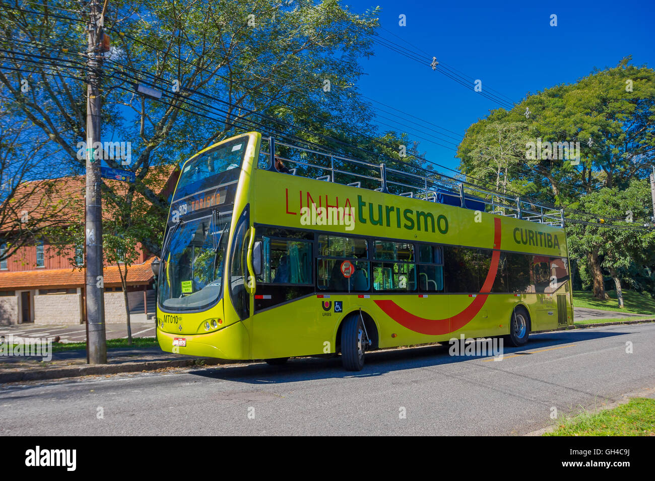 CURITIBA ,BRAZIL - MAY 12, 2016: green bus tour waiting on the stop parked in the street next to some trees Stock Photo