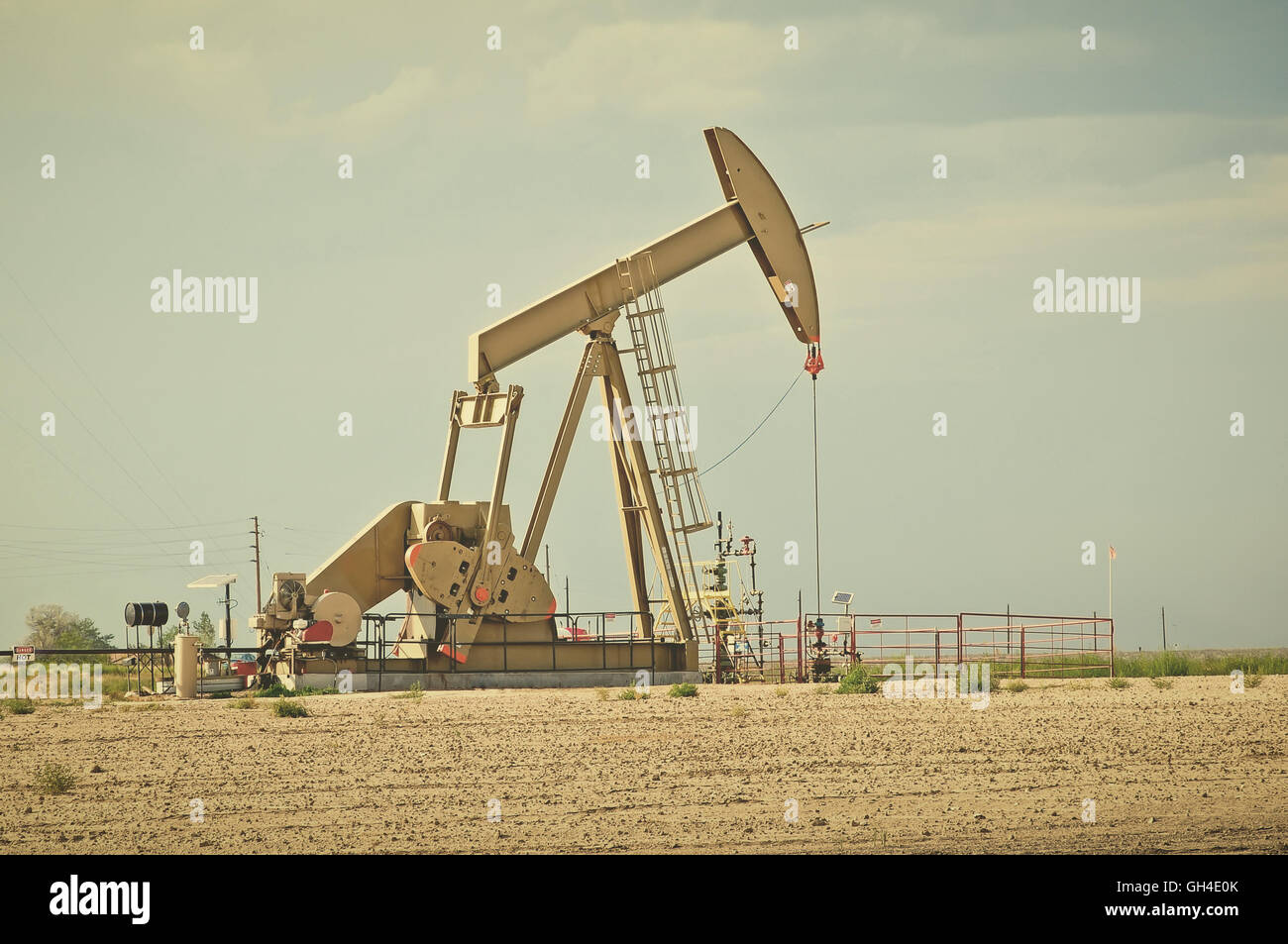 Large pump jack pumping crude oil up to the surface. Retro instagram look. Stock Photo