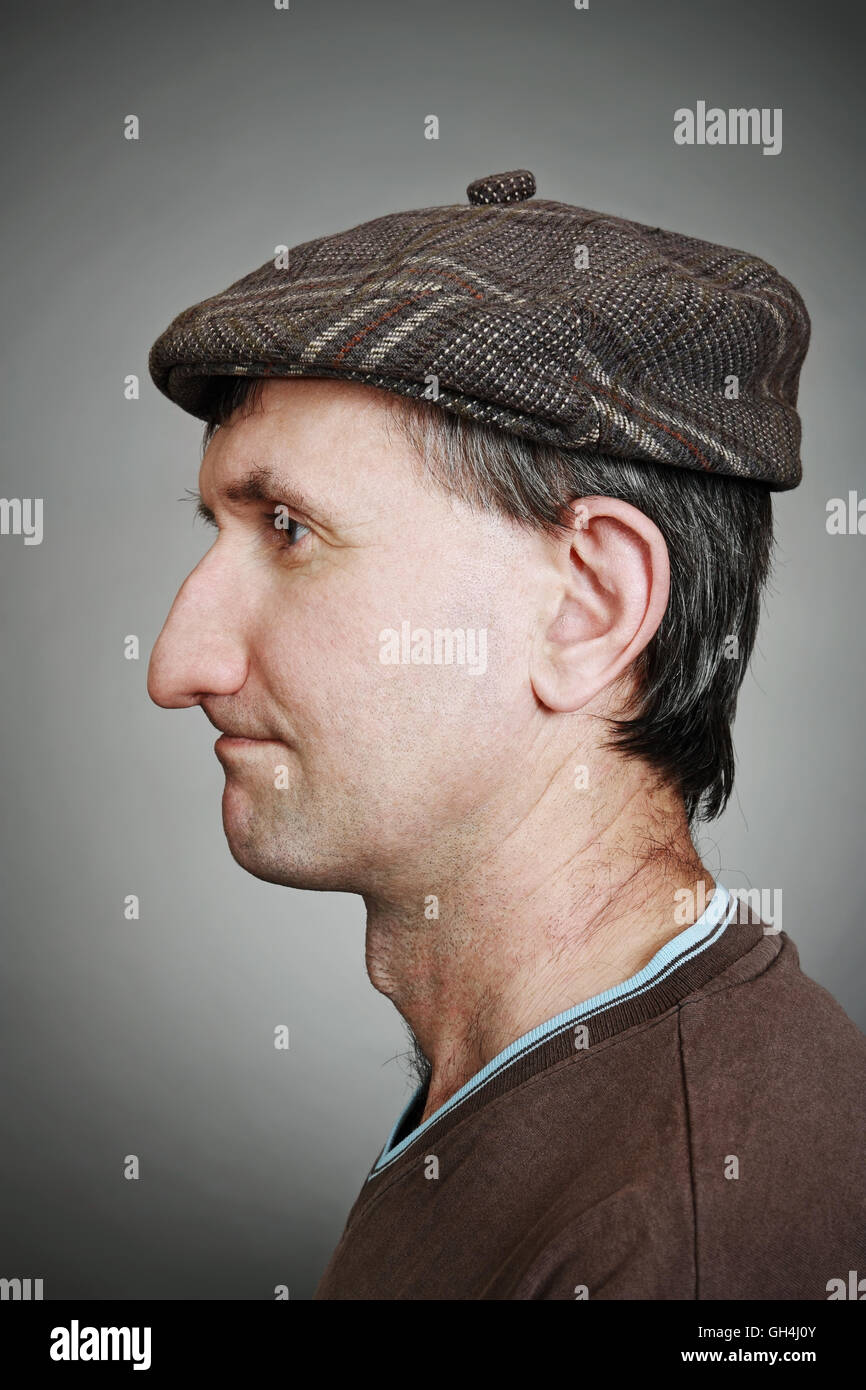 Portrait of a real man in a cap in profile on a gray background Stock Photo