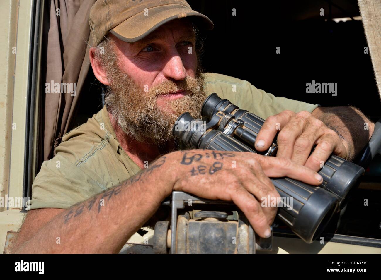 geography / travel, Namibia, lion researcher Dr. Flip Standert with spyglass in his research vehicle in the Obias riverbed, of a lateral branch of the Hoanib, Kaokoveld, Additional-Rights-Clearance-Info-Not-Available Stock Photo
