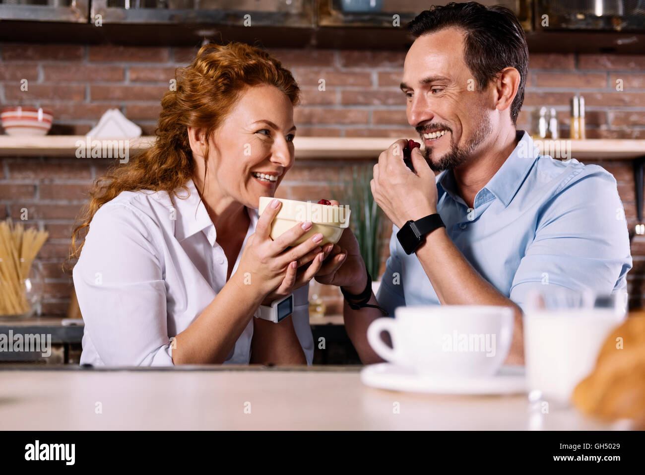 Man and woman eating strawberries Stock Photo - Alamy