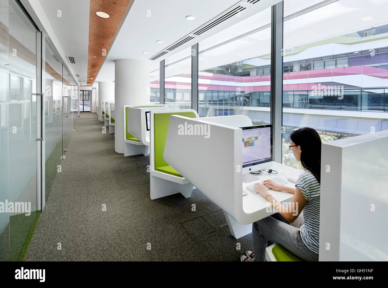 Corridor with window wall and individual IT desks. Singapore University of Technology and Design, Singapore, Singapore. Architect: UNStudio, 2015. Stock Photo