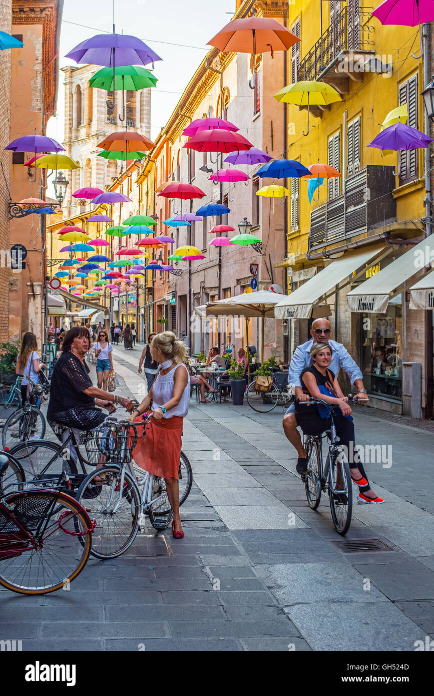 Via Giuseppe Mazzini of Ferrara covered with colored umbrellas and tower of San Giorgio cathedral in background. Italy. Stock Photo