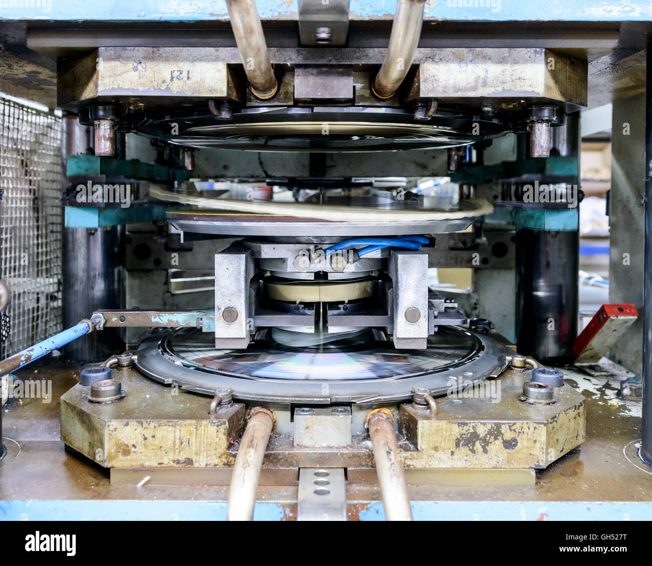 The record being pressed: the gold puck in the middle will be pressed against the negatives at the top and bottom to make the record - this will be a gold record. Record Industry Vinyl Factory, Haarlem, Netherlands. Architect: -, 1958. Stock Photo